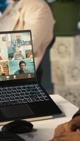 Vertical Employee having online discussion with coworkers in call meeting, working from office. Staff member in conference over the internet with teleworking colleagues, camera A video
