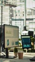 Vertical Tablet and PC on desk displaying financial graphs of company profits performance metrics. Data analytics on device display showing corporate business earnings KPIs. panning shot video