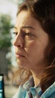 Vertical Stressed employee at office desk feeling tired while editing documents on computer. Overworked woman exhausted after inputting data in workplace at PC all day, feeling fatigue, camera B video