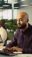 Vertical Accountant in busy modern startup agency working on PC, interrupted my manager asking him to check reports. Businessman working in office, tasked by supervisor to crosscheck paperwork data, camera B video