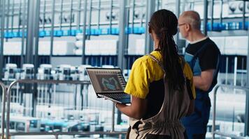 Engineering team working in smart factory, collecting and analyzing data. Teamworking colleagues using tracking software in industry 4.0 industrial plant equipped with advanced sensors, camera A video
