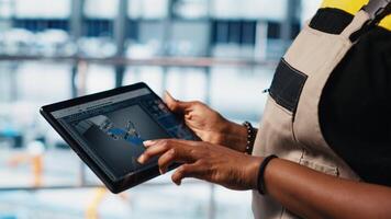 Photovoltaic smart factory specialist uses tablet to design production lines in CAD software. Industry 4.0 solar panels plant employee uses device to optimize floor layouts, camera A close up video