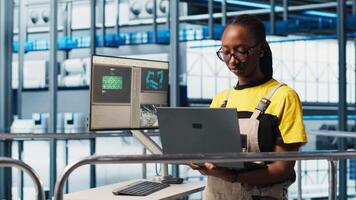 Portrait of happy engineer in smart photovoltaics factory looking at system performance metrics. Cheerful worker in solar panels plant tracking energy production through IoT sensors, camera A video