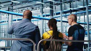 Industry 4.0 photovoltaics plant manager on industrial platform overseeing work done by engineers to maximize power generation. Solar panels smart factory team leader coordinating workers, camera A video