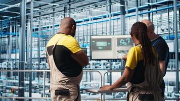 Smart photovoltaics factory staff members brainstorming, looking at system performance metrics. Solar panels plant colleagues discussing, tracking energy production through IoT sensors, camera A video
