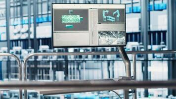 Monitor displaying industrial automation software overlooking industry 4.0 smart factory with robotic arms, modular production units, connected machines and control systems video