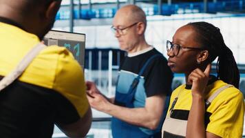 Engineer in photovoltaics smart factory talking with coworker, diagnosing malfunctioning IoT sensors. Industry 4.0 solar panels plant colleagues doing brainstorming to reduce downtime, camera A video