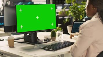 Office clerk working on green screen mockup PC to hit key performance targets for revenue and profitability. Employee at chroma key computer desk doing research analysis, camera A video