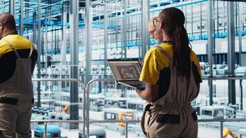 engenheiros dentro indústria 4,0 industrial plantar controlando automatizado maquinaria, garantindo fluxo de trabalho continuidade. técnicos dentro inteligente fábrica gerenciando robótico braços e transportador cintos, Câmera uma video