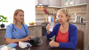 Caring doctor visits senior at home for a health checkup while providing support and comfort video