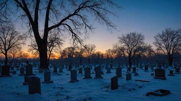 Graveyard Covered in Snow at Dusk with Bare Trees Silhouetted photo