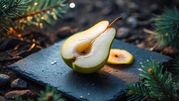 Pear Halved on Slate with Slice and Pine Boughs Background photo