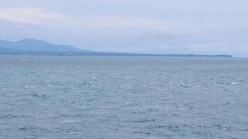 The ocean is calm and the waves are small. The water is a beautiful shade of blue photo