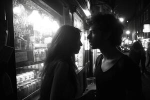 A romantic moment captured in silhouette, featuring a young couple, as they share an intimate gaze at night. photo