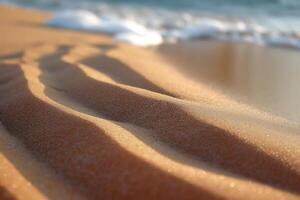 Gentle waves wash over fine golden sand, creating serene patterns and reflections of sunlight. photo
