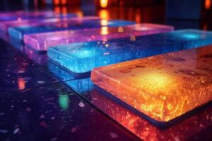 Vibrant colored ice blocks illuminated with soft lighting, showcasing a blend of blue and orange hues. photo