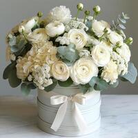 Elegant bouquet of white flowers in a soft grey container, exuding charm and freshness. photo
