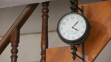 An elegant antique clock hangs, featuring intricate metal work and classic Roman numerals. photo