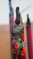 Thick, towering incense sticks burn brightly in front of the temple, releasing fragrant smoke that fills the air. photo