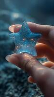 A delicate hand holding a translucent star-shaped charm, reflecting soft lights and shimmering patterns. photo