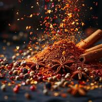 A vibrant spread of spices including cinnamon sticks, star anise, and colorful peppercorns against a dark background. photo