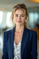 A young Caucasian woman in a stylish blazer poses confidently, showcasing a professional demeanor in a bright office setting. photo