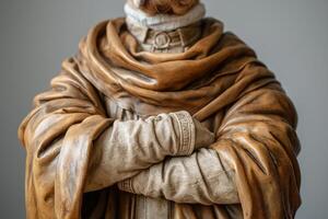 Intricate detail of a life-sized statue with textured robes and a solemn expression. photo
