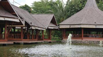 Traditional and Serene Retreat A charming bamboo gazebo stands above a koi pond, photo
