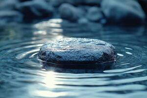 A tranquil stone rests on the surface of rippling water, reflecting soft light and creating a serene atmosphere. photo