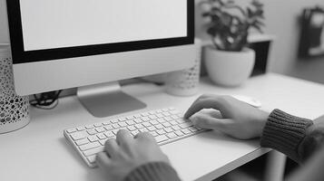 A close-up of a person typing on a sleek keyboard at a minimalist workspace, featuring a potted plant in the background. photo