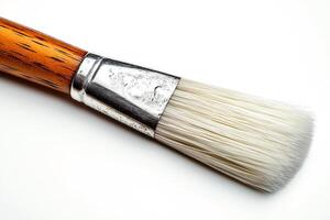 Close-up of a paintbrush with a wooden handle and soft bristles against a white background. photo