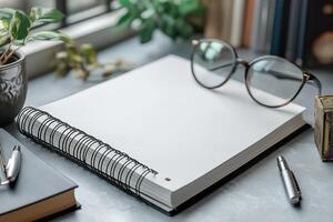 An open notebook and reading glasses on a stylish desk, surrounded by greenery, exuding a calm and creative workspace vibe. photo