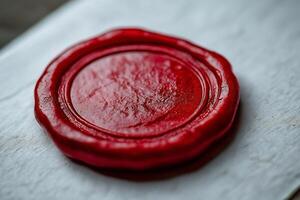 A detailed close-up of a red wax seal on a white surface, symbolizing authenticity and tradition. photo