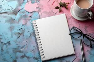 A serene workspace featuring a blank notebook, glasses, and coffee on a colorful textured background. photo