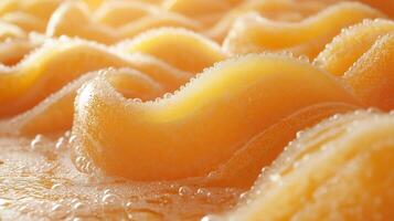 Close-up of vibrant orange wavy shapes, resembling soft foam waves, illuminated by warm golden light. photo