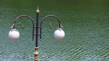 round white street lamp on the edge of the pool. photo