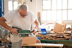Craftsman Using a Power Sander in His Workshop for Various Crafting Projects photo