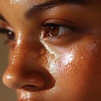 a womans skin, highlighting a combination skin type with visible oiliness on the forehead and nose, while the cheeks appear drier and slightly flaky photo