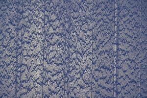 A waterfall runs down a blue wall in a striped design photo