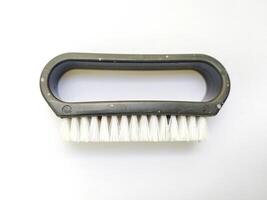 Closeup of a simple, handheld brush with a dark gray plastic handle and white bristles. Perfect for illustrating cleaning, maintenance, or detailing concepts. photo