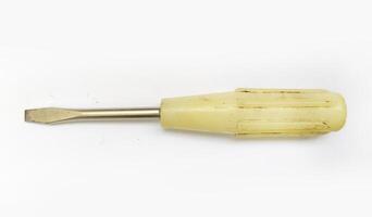 Vintage flathead screwdriver with a worn, offwhite handle. A simple tool, conveying themes of repair, craftsmanship, and the passage of time. photo