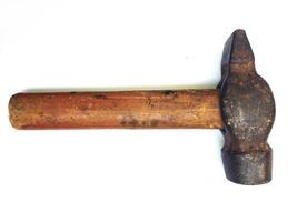 A wellworn hammer, its wooden handle showing age and use, rests against a clean white backdrop. photo