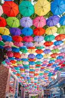 Multicolored bright colorful umbrellas decorating festive street on Magic City Park in Tashkent. Tashkent, Uzbekistan - June 15, 2024 photo