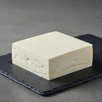 Fresh firm tofu block on slate plate photo