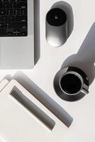 Top View of Modern Workspace with Laptop, Notebook, Coffee Cup and Mouse on Desk. photo