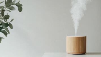 wooden essential oil diffuser emits mist on light surface photo