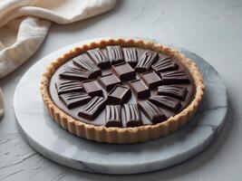 Decadent Chocolate Tart on Marble Surface with Dark Chocolate Squares and Soft Textile Background photo