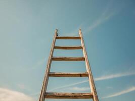 A ladder is standing in front of a blue sky photo