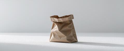 There is a brown paper bag sitting on a white surface. photo