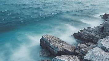 A rocky shoreline with waves crashing against it photo